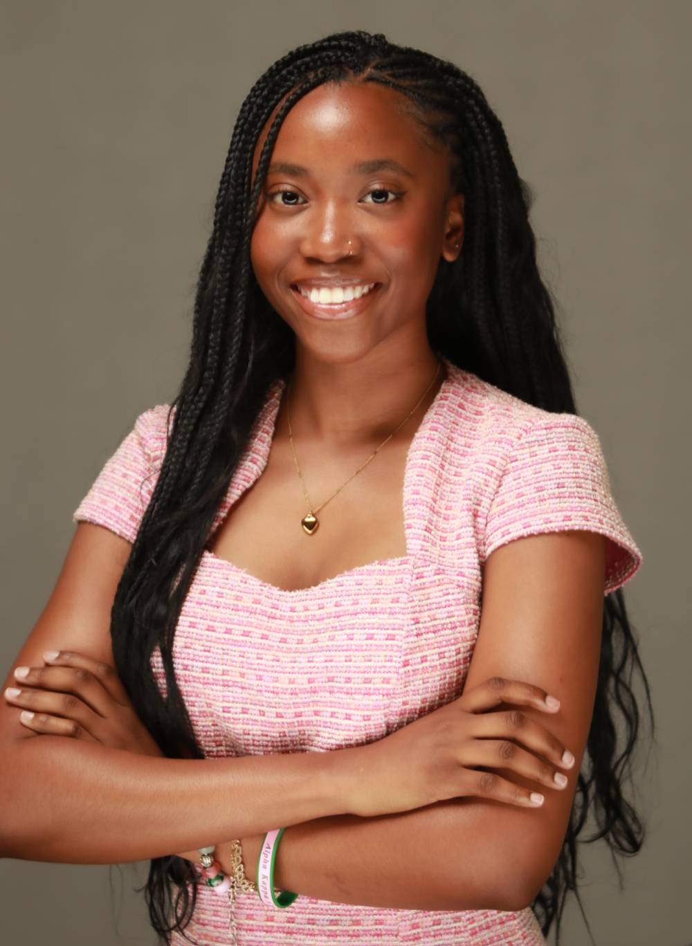Image 1 of 2 Woman posing for headshot with arms crossed, smiling